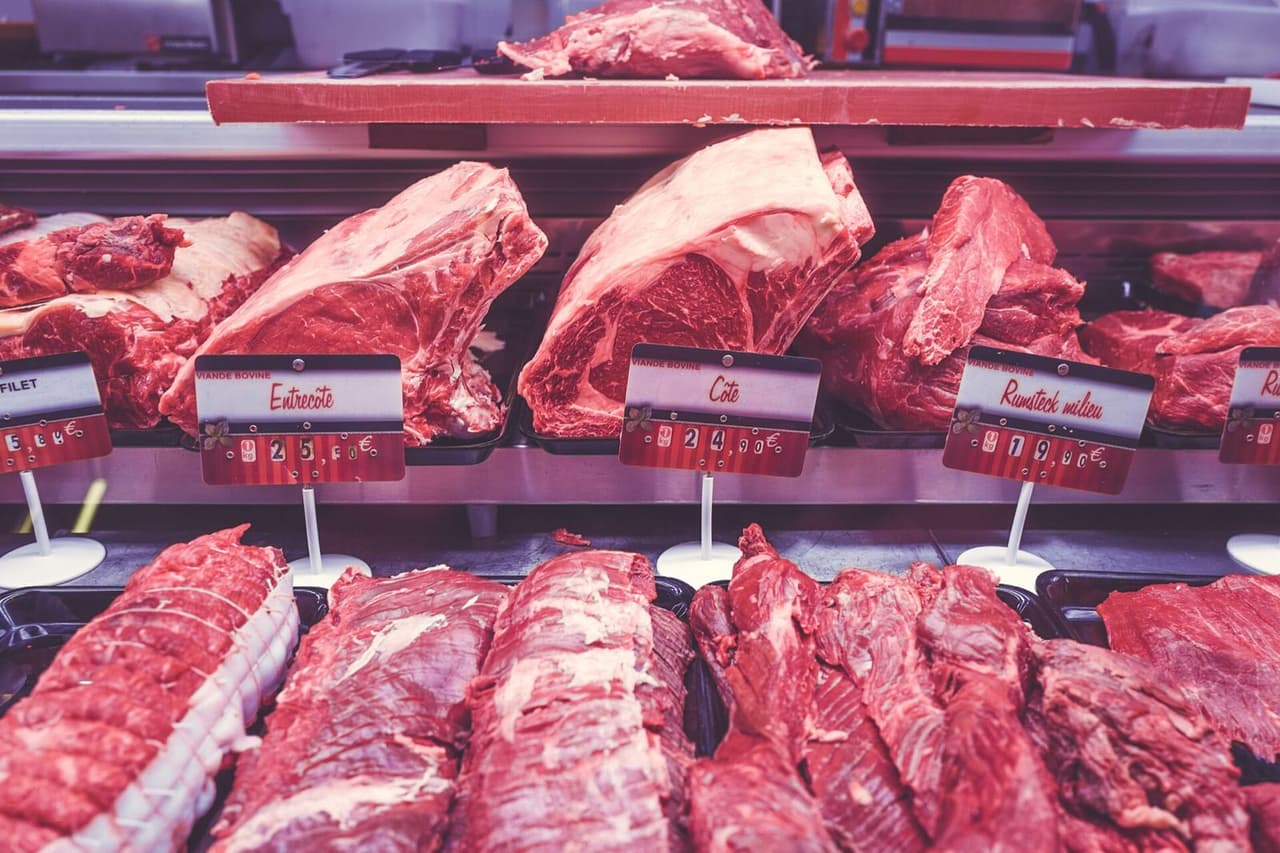 Cuts of beef in a butcher shop display with price labels